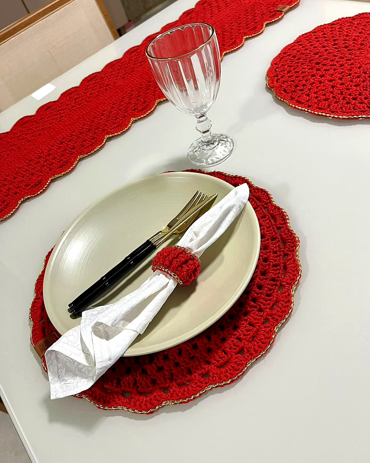 Lugar posto com sousplat, porta-guardanapo e caminho de mesa em crochê vermelho